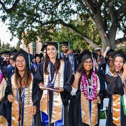 Five female students on graduation day on the UCR lawn.