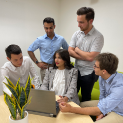 Five students studying together at a desk.